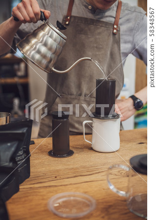 Barista is making alternative coffee with 58348567