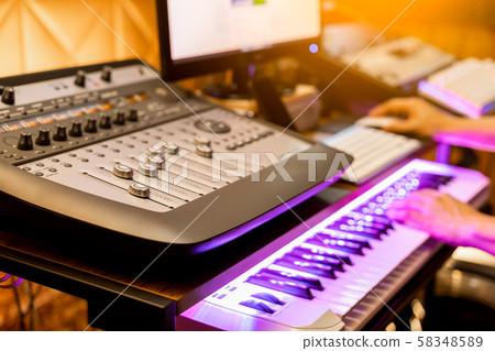 male musician composing a song in digital recording studio. shallow dept of field, focus on mixer fader male musician composing a song in digital recording studio. shallow dept of field, focus on mixer fader 58348589