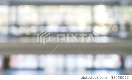 Blur background interior view looking out toward to empty office lobby and entrance doors and glass curtain wall 58350052