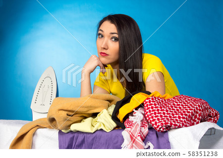 Houseworks, woman with pile of clothes for ironing Houseworks, woman with pile of clothes for ironing 58351238