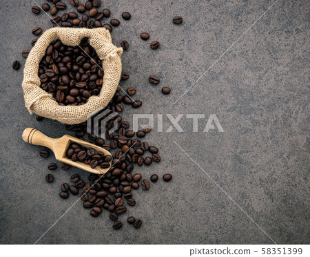 Dark roasted coffee beans on stone background. Top 58351399