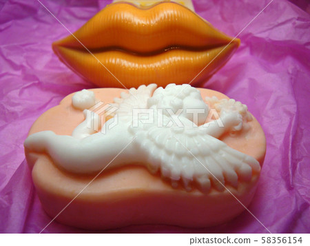 Bright orange lips. Kiss. White angel on a pink background. Cupid. Valentine's Day. Best gift. Fragrant soap.    58356154