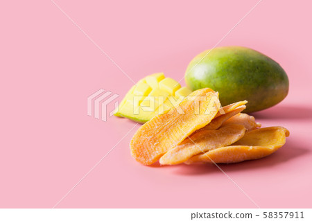 Dehydrated and dried mango chips on pink. Dehydrated and dried mango chips on pink. 58357911