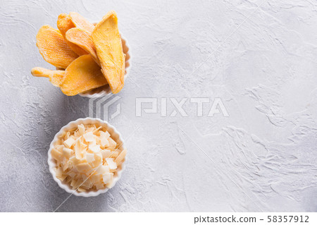 Dehydrated and dried mango and coconut chips. Dehydrated and dried mango and coconut chips. 58357912