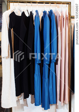 Close-up view of various stylish clothes hanging on hangers in boutique. Clothes Close-up view of various stylish clothes hanging on hangers in boutique. Clothes 58358007