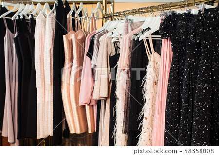 Close-up view of various stylish clothes hanging on hangers in boutique. Clothes Close-up view of various stylish clothes hanging on hangers in boutique. Clothes 58358008