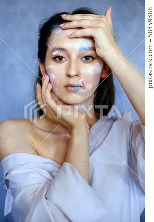 Creative fashion beauty portrait of a beautiful young woman with an artistic tassel in her hands. Creative fashion beauty portrait of a beautiful young woman with an artistic tassel in her hands. 58359388