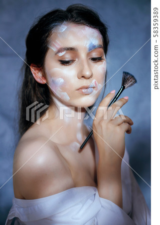 Creative fashion beauty portrait of a beautiful young woman with an artistic tassel in her hands. 58359389