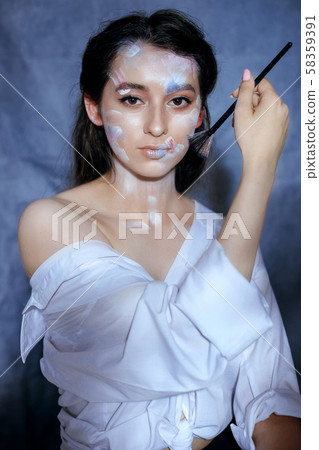 Creative fashion beauty portrait of a beautiful young woman with an artistic tassel in her hands. Creative fashion beauty portrait of a beautiful young woman with an artistic tassel in her hands. 58359391