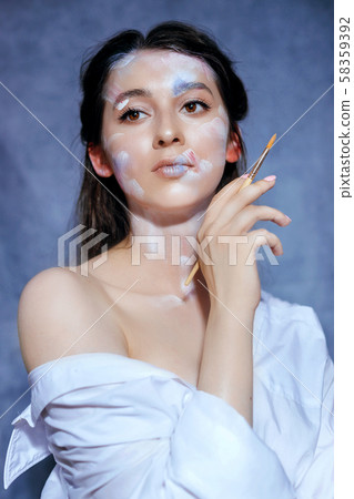 Creative fashion beauty portrait of a beautiful young woman with an artistic tassel in her hands. Creative fashion beauty portrait of a beautiful young woman with an artistic tassel in her hands. 58359392
