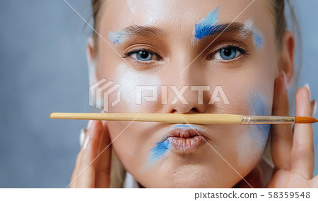 Creative fashion beauty portrait of a beautiful young blonde woman with an artistic tassel in her hands. 58359548