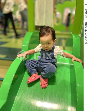 Girl playing on the slide 58360101