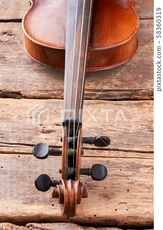 Old violin part on wooden planks close up. 58360319