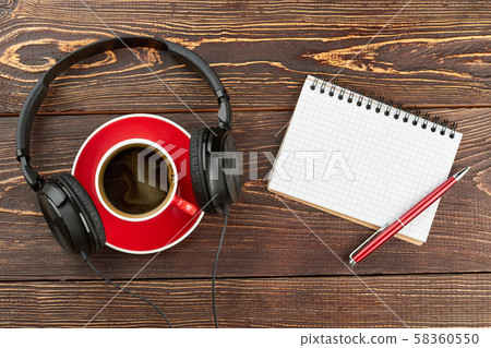 Headphones with cup and blank notebook. 58360550