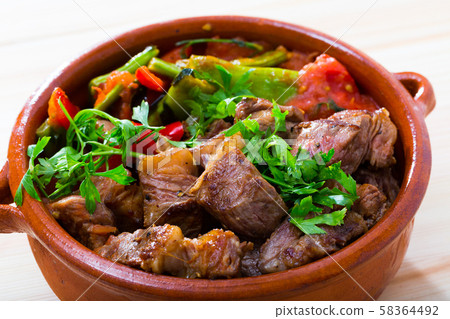 Cooked gyuvech dish of bulgarian cuisine of beef with vegetables at clay pot Cooked gyuvech dish of bulgarian cuisine of beef with vegetables at clay pot 58364492