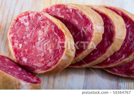 Salchichon spanish sausage slices on wooden desk 58364767
