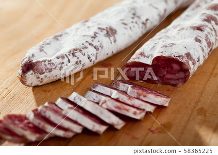 Spanish sausage fuet on a wooden table, closeup Spanish sausage fuet on a wooden table, closeup 58365225