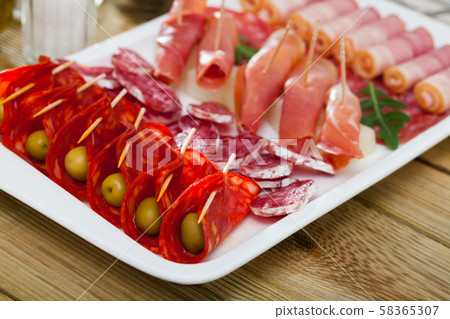 Slices of gammon, sausages, bacon on rectangular plate Slices of gammon, sausages, bacon on rectangular plate 58365307