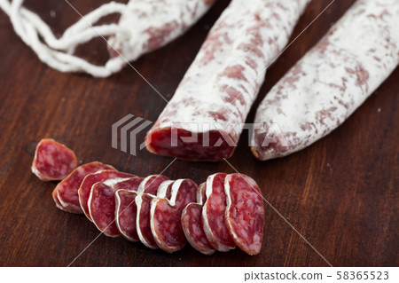 Spanish sausage fuet on a wooden table, closeup Spanish sausage fuet on a wooden table, closeup 58365523