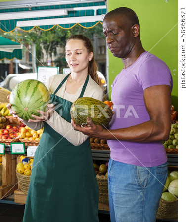 Man client is asking from seller female about freshness watermelon and melon 58366321