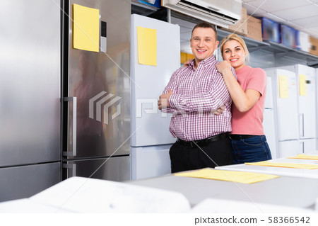 Positive couple standing in store of household appliances 58366542
