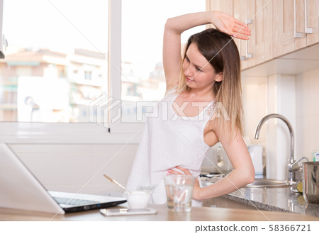 Pretty girl is training near laptop in time morning exercises 58366721