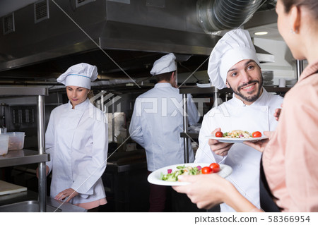 Staff of restaurant with head chef working Staff of restaurant with head chef working 58366954
