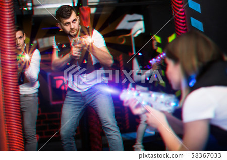 Excited guy laser tag player in bright beams 58367033