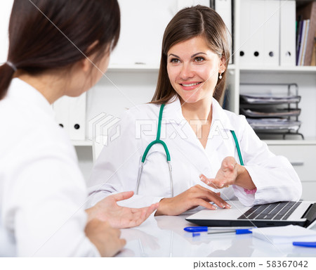 Female doctor consulting patient Female doctor consulting patient 58367042