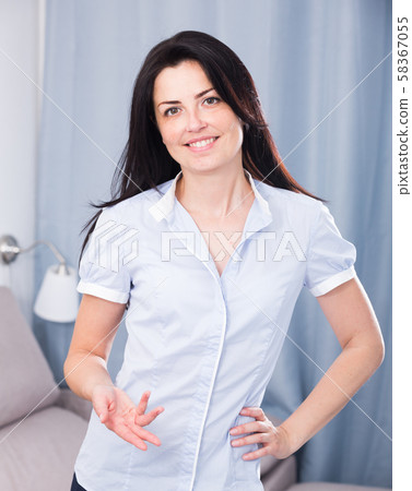 smiling female offering one's hand indoors 58367055