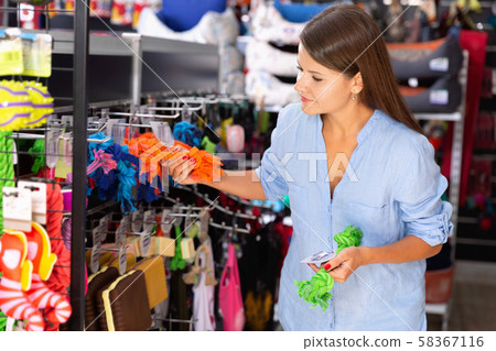 Portrait of positive girl buying pet supplies in modern petshop Portrait of positive girl buying pet supplies in modern petshop 58367116