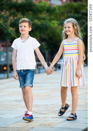 Two kids walking together outdoor 58367169