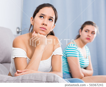 Quarreled girls apart on couch 58367241