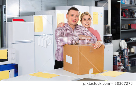 Couple with packed purchases in household appliances section in shop Couple with packed purchases in household appliances section in shop 58367273