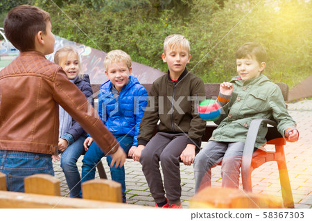 Children playing with ball on bench Children playing with ball on bench 58367303