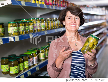 Portrait of an elderly woman buying a cucumbers Portrait of an elderly woman buying a cucumbers 58367305