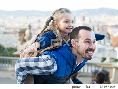 Adult father and daughter taking walk in city Adult father and daughter taking walk in city 58367306