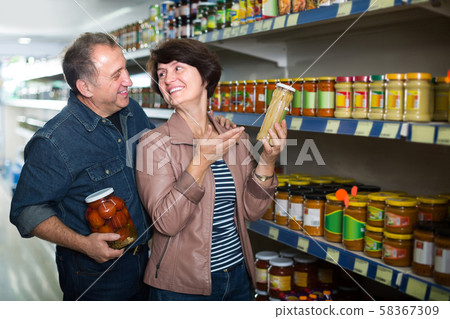 Portrait of an elderly couple buying a snacks at the grocery store 58367309