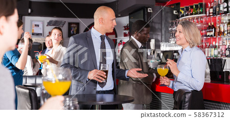 Mature woman with male colleague on corporate party Mature woman with male colleague on corporate party 58367312