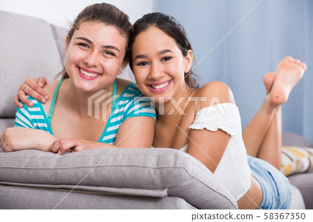 Cheerful teens girls laughing on couch 58367350