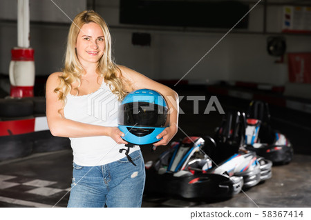 Pretty woman with helmet standing near cars Pretty woman with helmet standing near cars 58367414