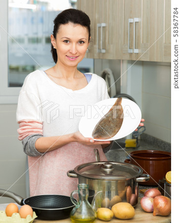 Woman holding plate with common sole Woman holding plate with common sole 58367784