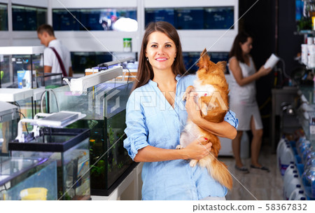 Woman with dog walking in pet store Woman with dog walking in pet store 58367832