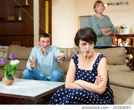 Unhappy woman during family conflict, emotional man on background Unhappy woman during family conflict, emotional man on background 58368085
