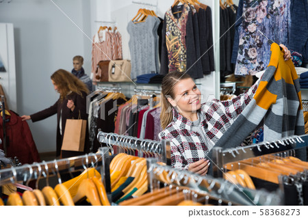 Woman choosing warm cardigan Woman choosing warm cardigan 58368273