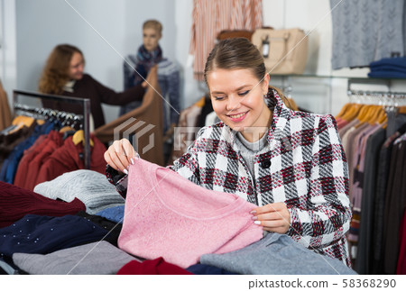 Woman choosing cardigan in clothing shop Woman choosing cardigan in clothing shop 58368290