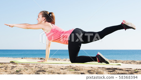 Smiling young woman in track-suit active training Smiling young woman in track-suit active training 58368394