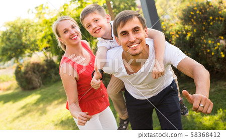 family of three in park in summer day . 58368412