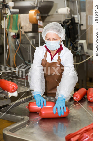 Woman working on sausage automatic line Woman working on sausage automatic line 58368415