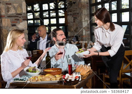 Waitress bringing meals to visitors Waitress bringing meals to visitors 58368417